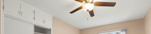 One Bedroom Apartments with Van Nuys, CA - Colonial Manor Spacious Bedroom with Carpet Flooring, Large Closet, and Ceiling Fan