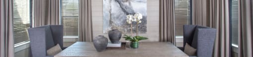a dining room with a table and chairs and a painting on the wall