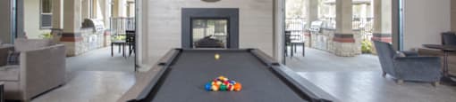 a pool table in a living room with a fireplace