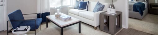 a living room with a couch and a coffee table and a ceiling fan