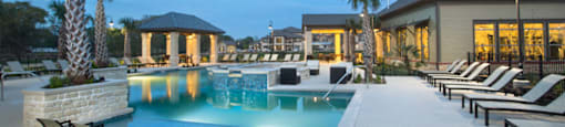 a swimming pool with chairs and a building in the background