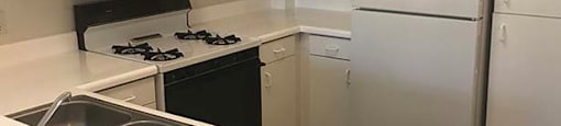 Full kitchen view with appliances at KLIMPEL MANOR Apartments, Fullerton, California