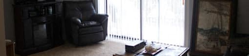 Living room decor with balcony at Trenton Place Apartments, Willoughby, OH