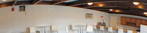 a large community room with tables and chairs  at Valley York Apartments, Parma Heights