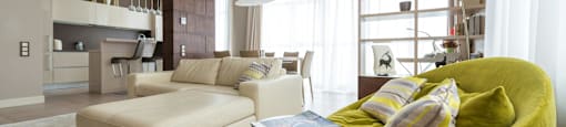 A modern living room with a green chair and a white couch.