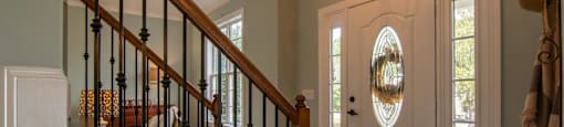 A staircase with a black railing and a light brown carpet.