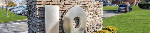 A stone pillar with a large circular metal piece on it.