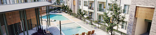 an aerial view of an apartment complex with a pool and lounge chairs