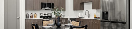 a kitchen and dining room with stainless steel appliances and a table and chairs