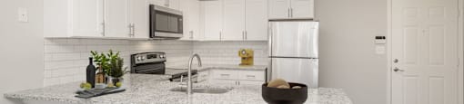 a kitchen with white cabinets and a granite counter top