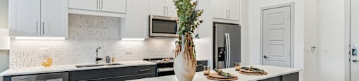 an open kitchen with a large island with two stools