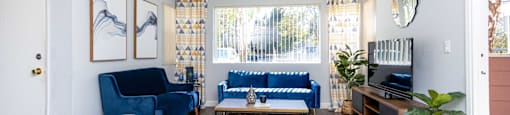 a living room with blue couches and a tv