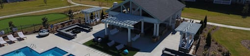 an aerial view of a swimming pool with a clubhouse and a resort style poolside