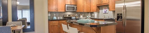 an open kitchen with stainless steel appliances and wooden cabinets