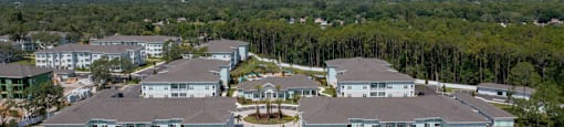 an aerial view of an apartment complex with roads and trees
