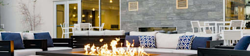 the outdoor patio of a building with a fire pit