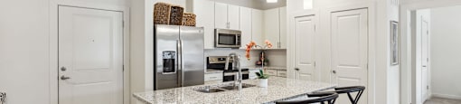 a kitchen with a marble counter top and bar stools