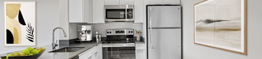 Upgraded modern kitchen with stainless steel appliances and white cabinets