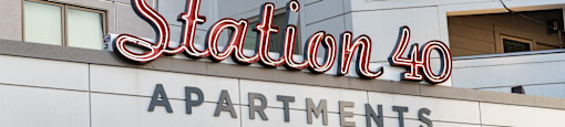 a sign for station 40 apartments on the side of a building