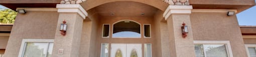 A house with a stone archway entrance and two doors.