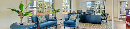a living room with blue chairs and a large window