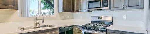 A kitchen with dark wood cabinets and stainless steel appliances.