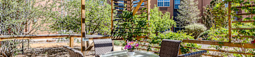 a patio with a table and chairs under a roof