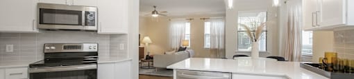 a kitchen with white cabinets and stainless steel appliances at Sladestone Shadow Creek, Pearland