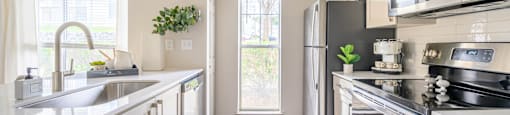 a modern kitchen with stainless steel appliances and white cabinets at Ashford Green, NC 28262