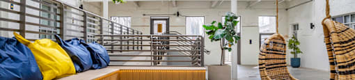 a living room with two hammock chairs and a wooden bench at Highland Mill Lofts, Charlotte, 28205
