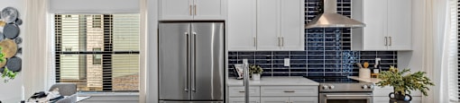 a kitchen with white cabinets and a large island with a sink at The Collection Charlotte in Charlotte, NC, 28205