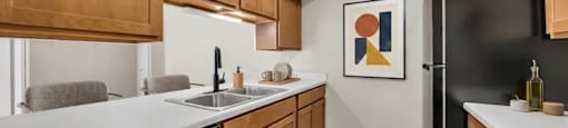 A kitchen with wooden cabinets and black appliances.