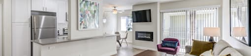 Encino Apartments- Brookside Terrace Apartments- Living Room Setting that has a Tan Couch with a Nude Area Rug and Wooden Coffee Table