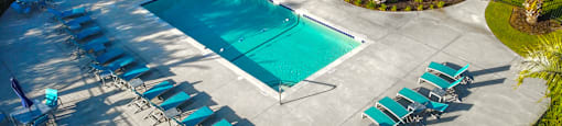a swimming pool with chairs and chairs around it at Planters Trace Apartment Homes, South Carolina