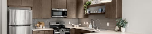 A modern kitchen with a white countertop and brown chairs.