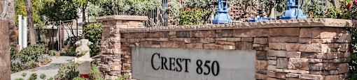 a stone wall with a sign that reads crest 860 in front of a building