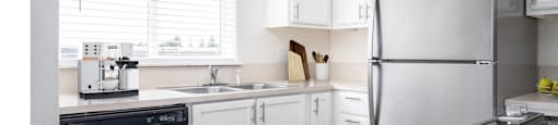 a kitchen with white cabinets and stainless steel appliances