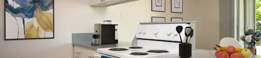 a kitchen with white appliances and white cabinets and a window
