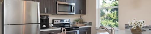 a kitchen with stainless steel appliances and a bowl of fruit