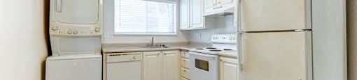 A kitchen with white appliances and wooden floors.