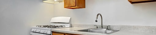 A kitchen with a white stove and wooden cabinets.