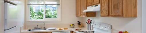 A kitchen with wooden cabinets and white appliances.
