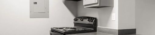 A kitchen with black appliances and white cabinets.