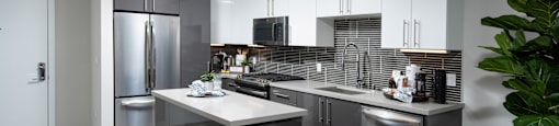 a kitchen with white cabinets and stainless steel appliances
