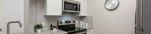 Bourg Du Village kitchen open concept kitchen with quartz countertop and stainless steel appliances in Sainte Therese, QC