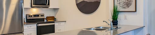 Kitchen featuring quartz countertops with built-in breakfast bar at Bayfield Tower Apartments in Barrie, ON