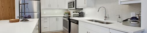 Watson Park Apartments kitchen featuring stainless steel appliances and white cabinets in Guelph, ON