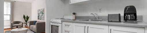 A kitchen with white cabinets and a black toaster.