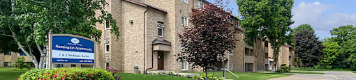 Kensington Apartments in Brockville Ontario showing a blue and white community sign and building in the background