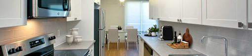 Regency Towers modern kitchen with white cabinetry and stainless steel appliances in Owen Sound, ON